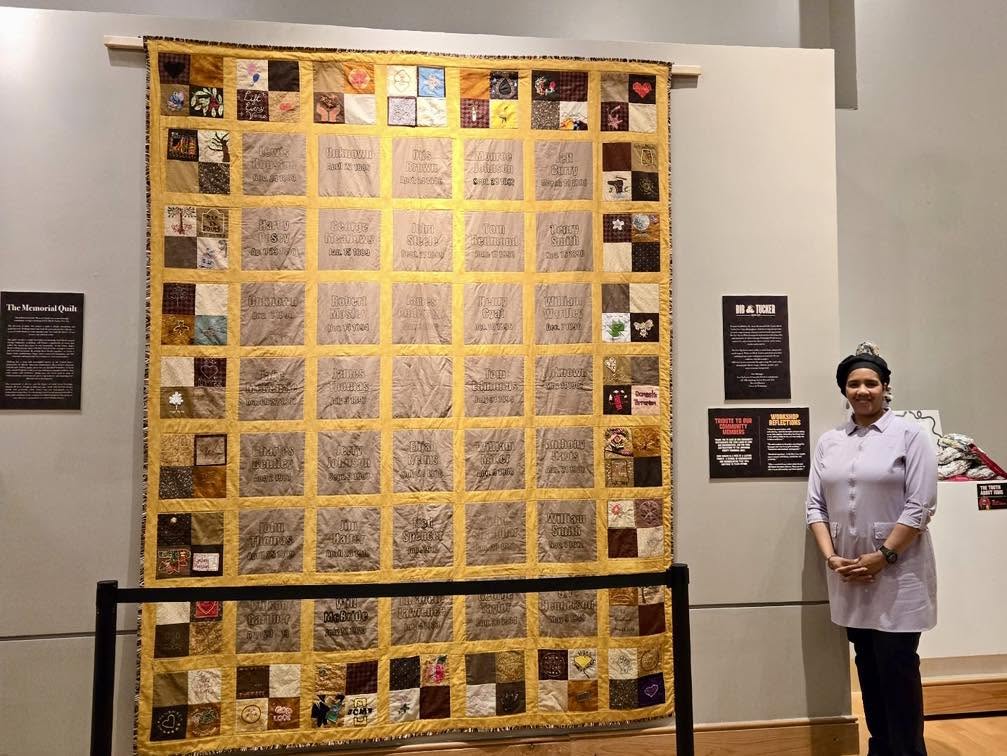 The completed Jefferson County Memorial Quilt, with gold sashing, central name panels, and community-made blocks along its border