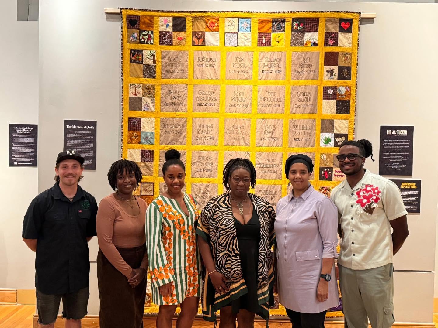 Community members standing together in front of the finished Jefferson County Memorial Quilt